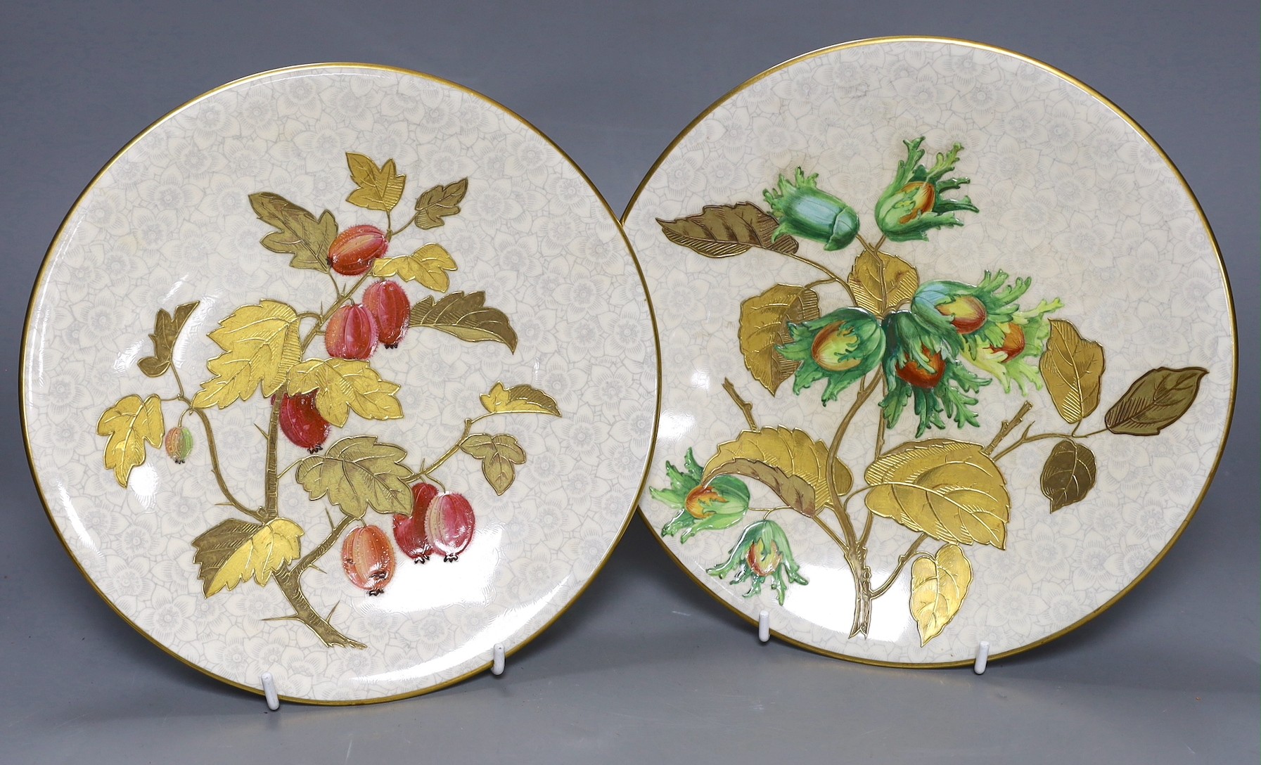 Three Royal Worcester Aesthetic period plates, with raised gilded and enamelled botanical decoration, on a floral ground, originally retailed by Gardner’s Strand, London. 23cm diameter.